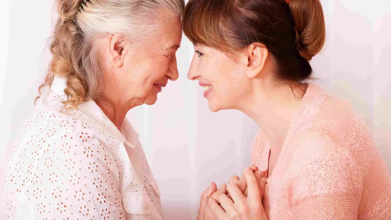 Un abbraccio tra madre e figlia, un momento di affetto che può aiutare a gestire i sintomas de alzheimer, con mani che si stringono.