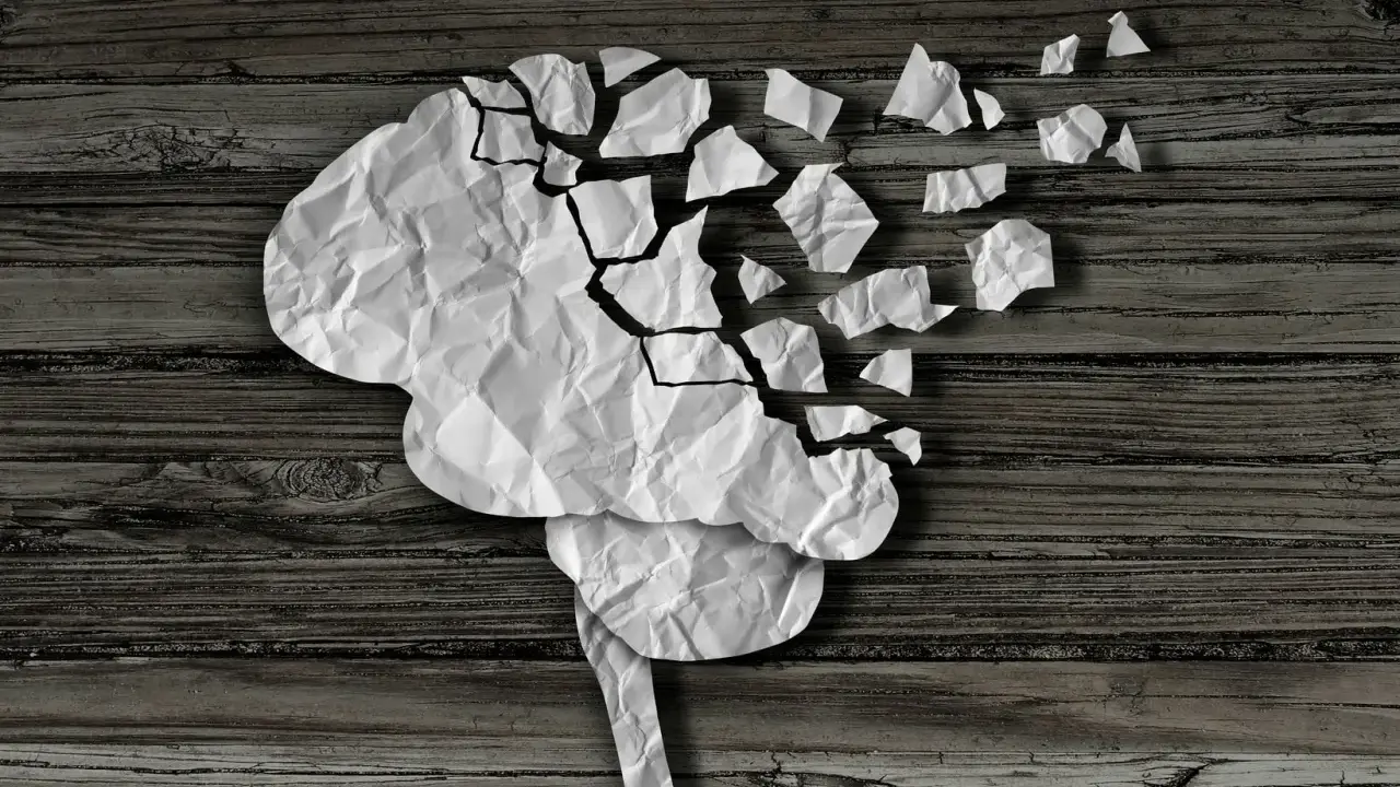 Cervello di carta sgretolato, simbolo dei vuoti di memoria negli anziani. Frammenti che si staccano, come ricordi perduti.