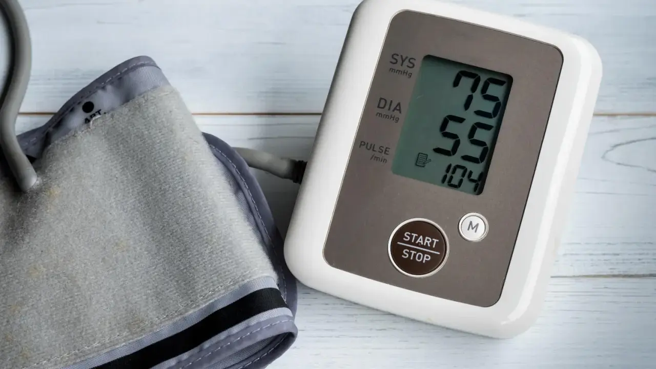 Misuratore di pressione con bracciale e display che mostra 75/55, valori che potrebbero indicare pressione bassa anziani 90 anni.