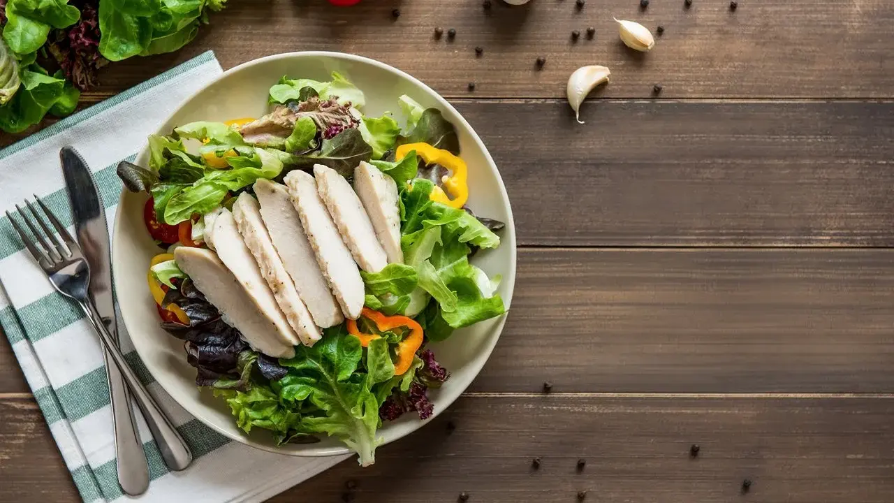 Insalata fresca con pollo grigliato, peperoni colorati e pomodorini. Un piatto che fa venire fame, pronto per essere gustato.