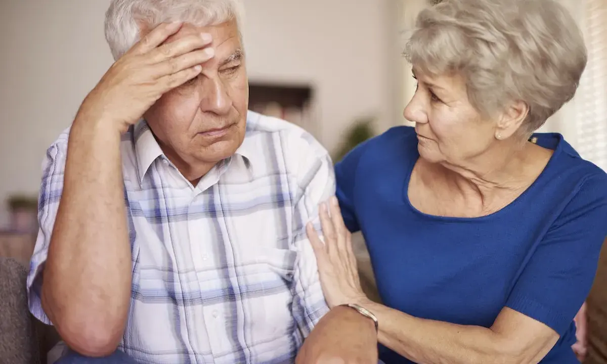 Donna conforta uomo con demenza senile, preoccupato per problemi di defecazione.