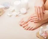 Piedi curati e mani perfette: il podologo fa la pedicure, con smalti rosa e bianchi pronti per un tocco finale.