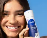 Donna sorridente con prodotto Nivea Derma Control. Soluzione per la dermatite ascellare cura.