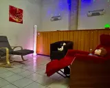 Una stanza snoezelen accogliente con sedie comode, luci soffuse e un'atmosfera rilassante.
