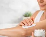 Donna applica crema idratante sul braccio per alleviare il prurito sine materia.