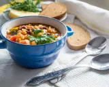 Zuppa nutriente, ideale per una dieta per anziani over 90. Servita in ciotola blu con pane integrale e erbe fresche.