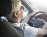 Anziana al volante, con mani sul volante, potrebbe suggerire il tema del decadimento cognitivo nell'anziano e la sua autonomia.
