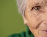 Primo piano di un occhio e parte del viso di un'anziana. Potrebbe rappresentare la ricerca di gocce calmanti per demenza senile.