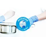 Mani guantate presentano una padella metallica, pronta per essere usata. Il logo MEIKO sottolinea l'igiene.