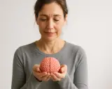 Donna con un modello di cervello tra le mani, simbolo della plasticità neuronale e del potenziale di apprendimento.