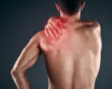 Uomo con mano sulla spalla, evidenziata in rosso, che indica dolore muscolare, forse mialgia da farmaci.