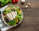 Insalata fresca con pollo grigliato, peperoni colorati e pomodorini. Un piatto che fa venire fame, pronto per essere gustato.
