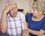 Donna conforta uomo con demenza senile, preoccupato per problemi di defecazione.