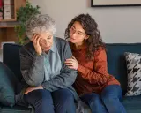 Una giovane donna conforta un'anziana con Alzheimer, mostrando quando ricoverare un malato di Alzheimer.