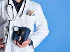 Medico con camice bianco, stetoscopio, appunti e sfigmomanometro, pronto a controllare i pressione valori normali.