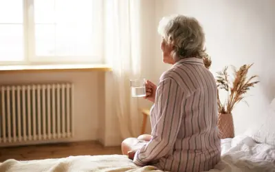 Anziani fragili, la disidratazione può portare alla morte. Una donna anziana beve un bicchiere d'acqua.