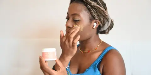 Donna applica crema viso per ammorbidire la pelle vecchia.