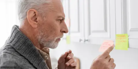 Uomo anziano con Alzheimer, confuso, cerca di ricordare con post-it. Peggioramento improvviso.