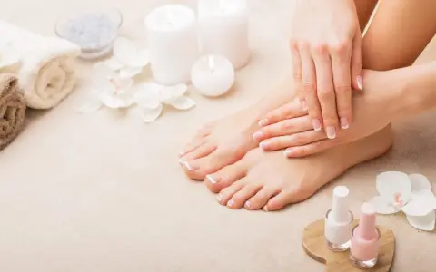 Piedi curati e mani perfette: il podologo fa la pedicure, con smalti rosa e bianchi pronti per un tocco finale.
