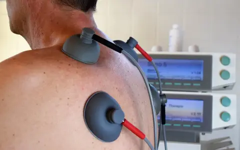 Elettrodi applicati sulla schiena per terapia, forse per alleviare il prurito alla schiena. Rimedi moderni per il benessere.
