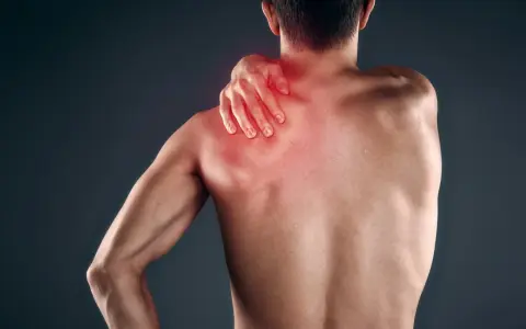 Uomo con mano sulla spalla, evidenziata in rosso, che indica dolore muscolare, forse mialgia da farmaci.