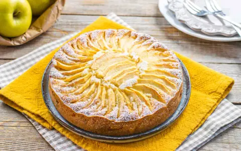 Torta di mele fatta in casa, perfetta come dolci per diabetici. Decorata con fettine di mela e zucchero a velo.