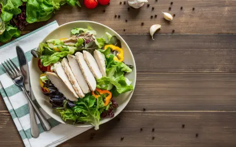 Insalata fresca con pollo grigliato, peperoni colorati e pomodorini. Un piatto che fa venire fame, pronto per essere gustato.