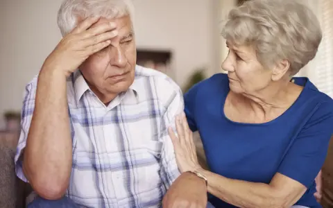 Donna conforta uomo con demenza senile, preoccupato per problemi di defecazione.