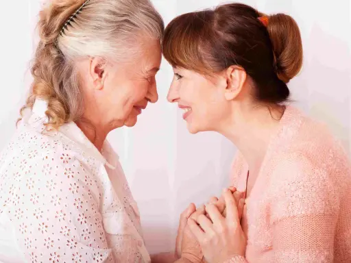 Un abbraccio tra madre e figlia, un momento di affetto che può aiutare a gestire i sintomas de alzheimer, con mani che si stringono.
