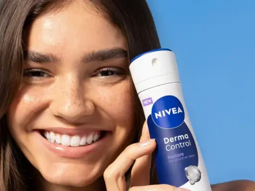 Donna sorridente con prodotto Nivea Derma Control. Soluzione per la dermatite ascellare cura.