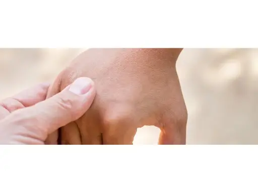 Mano adulta che accarezza delicatamente la mano di un bambino, notando una lieve irritazione cutanea che potrebbe far pensare a una falsa scabbia.