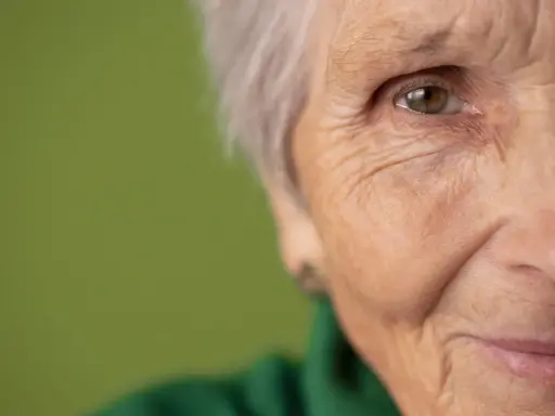 Primo piano di un occhio e parte del viso di un'anziana. Potrebbe rappresentare la ricerca di gocce calmanti per demenza senile.
