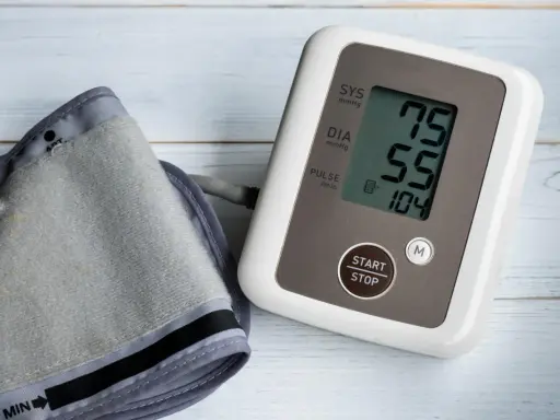 Misuratore di pressione con bracciale e display che mostra 75/55, valori che potrebbero indicare pressione bassa anziani 90 anni.