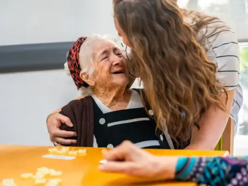 Giovane abbraccia anziana sorridente, un momento di affetto che contrasta il timore del decadimento cognitivo improvviso.