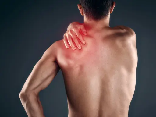 Uomo con mano sulla spalla, evidenziata in rosso, che indica dolore muscolare, forse mialgia da farmaci.