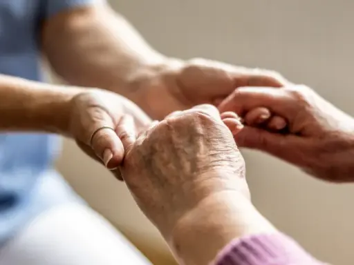 Mani che si stringono, un gesto di cura e supporto. Un'immagine che evoca il valore del bonus caregiver e l'importanza di chi assiste gli altri.