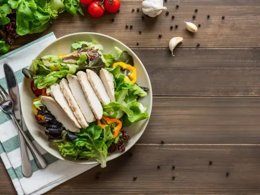 Insalata fresca con pollo grigliato, peperoni colorati e pomodorini. Un piatto che fa venire fame, pronto per essere gustato.