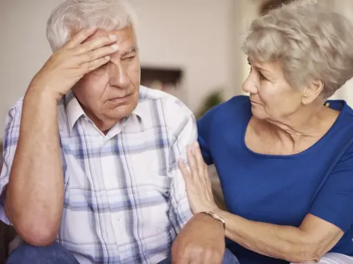Donna conforta uomo con demenza senile, preoccupato per problemi di defecazione.