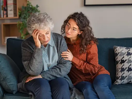 Una giovane donna conforta un'anziana con Alzheimer, mostrando quando ricoverare un malato di Alzheimer.