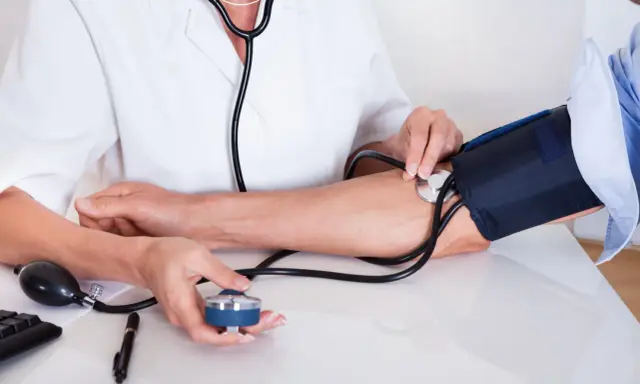 Medico misura la pressione arteriosa per verificare quanto è la pressione normale.