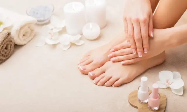 Piedi curati e mani perfette: il podologo fa la pedicure, con smalti rosa e bianchi pronti per un tocco finale.