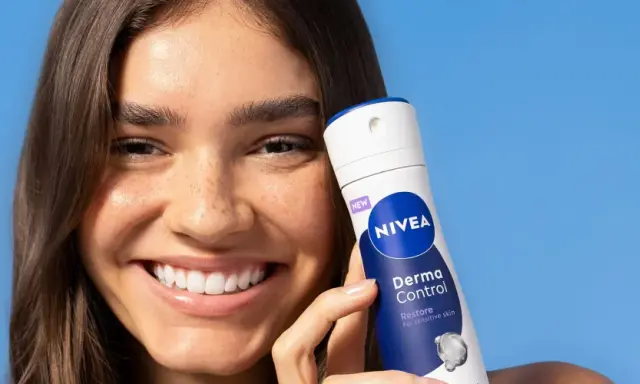 Donna sorridente con prodotto Nivea Derma Control. Soluzione per la dermatite ascellare cura.