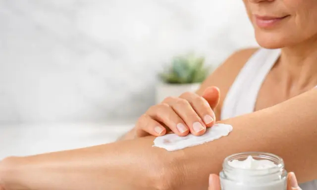 Donna applica crema idratante sul braccio per alleviare il prurito sine materia.