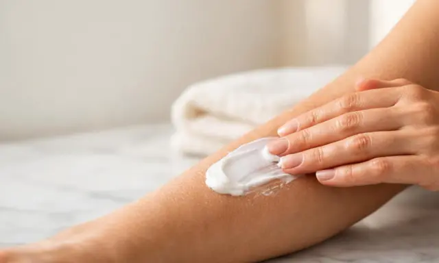 Mano che applica crema su un braccio, un rimedio per il prurito psicosomatico.