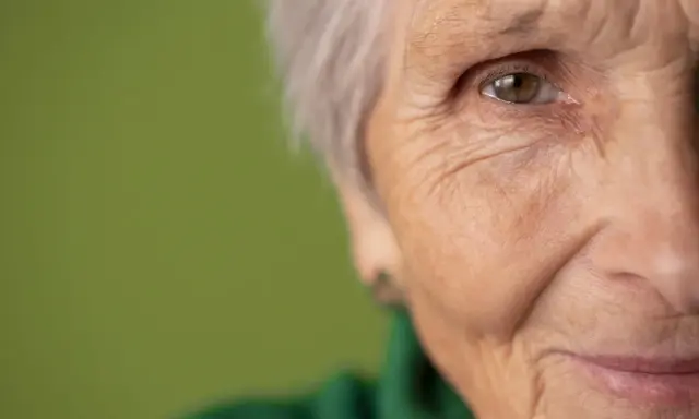 Primo piano di un occhio e parte del viso di un'anziana. Potrebbe rappresentare la ricerca di gocce calmanti per demenza senile.