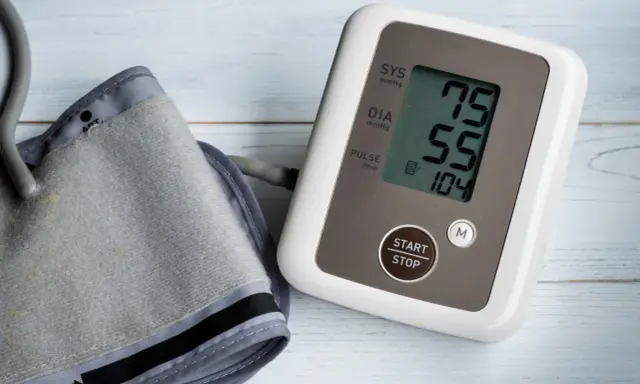 Misuratore di pressione con bracciale e display che mostra 75/55, valori che potrebbero indicare pressione bassa anziani 90 anni.