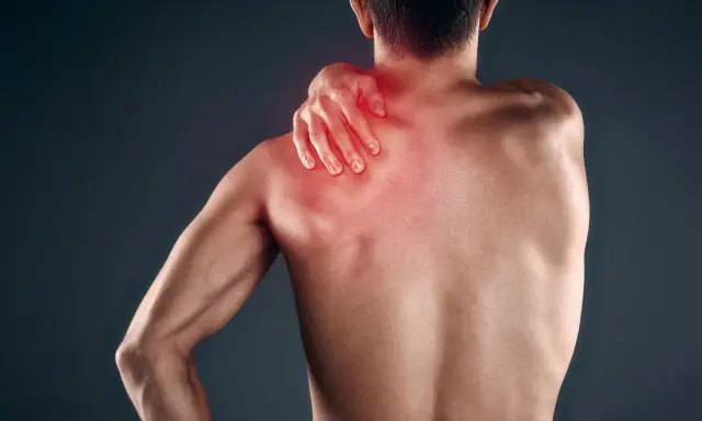 Uomo con mano sulla spalla, evidenziata in rosso, che indica dolore muscolare, forse mialgia da farmaci.