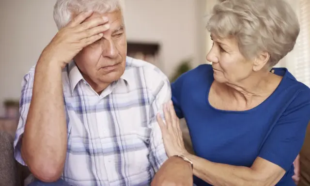 Donna conforta uomo con demenza senile, preoccupato per problemi di defecazione.