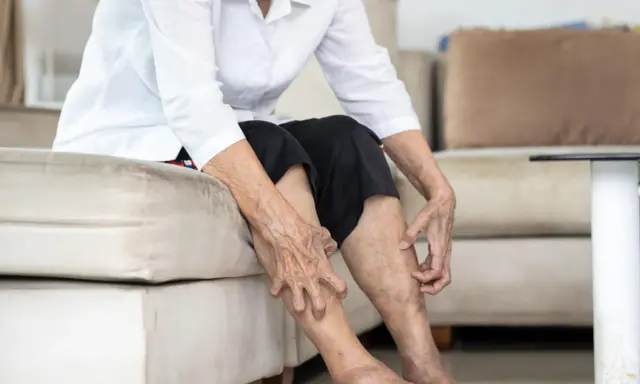 Gambe anziani con pelle secca e macchie, che indicano il passare del tempo e la necessità di cure.