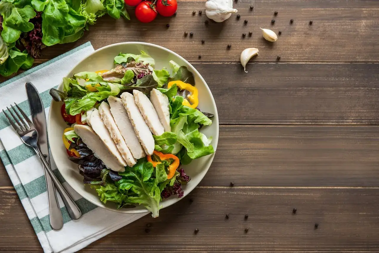Insalata fresca con pollo grigliato, peperoni colorati e pomodorini. Un piatto che fa venire fame, pronto per essere gustato.